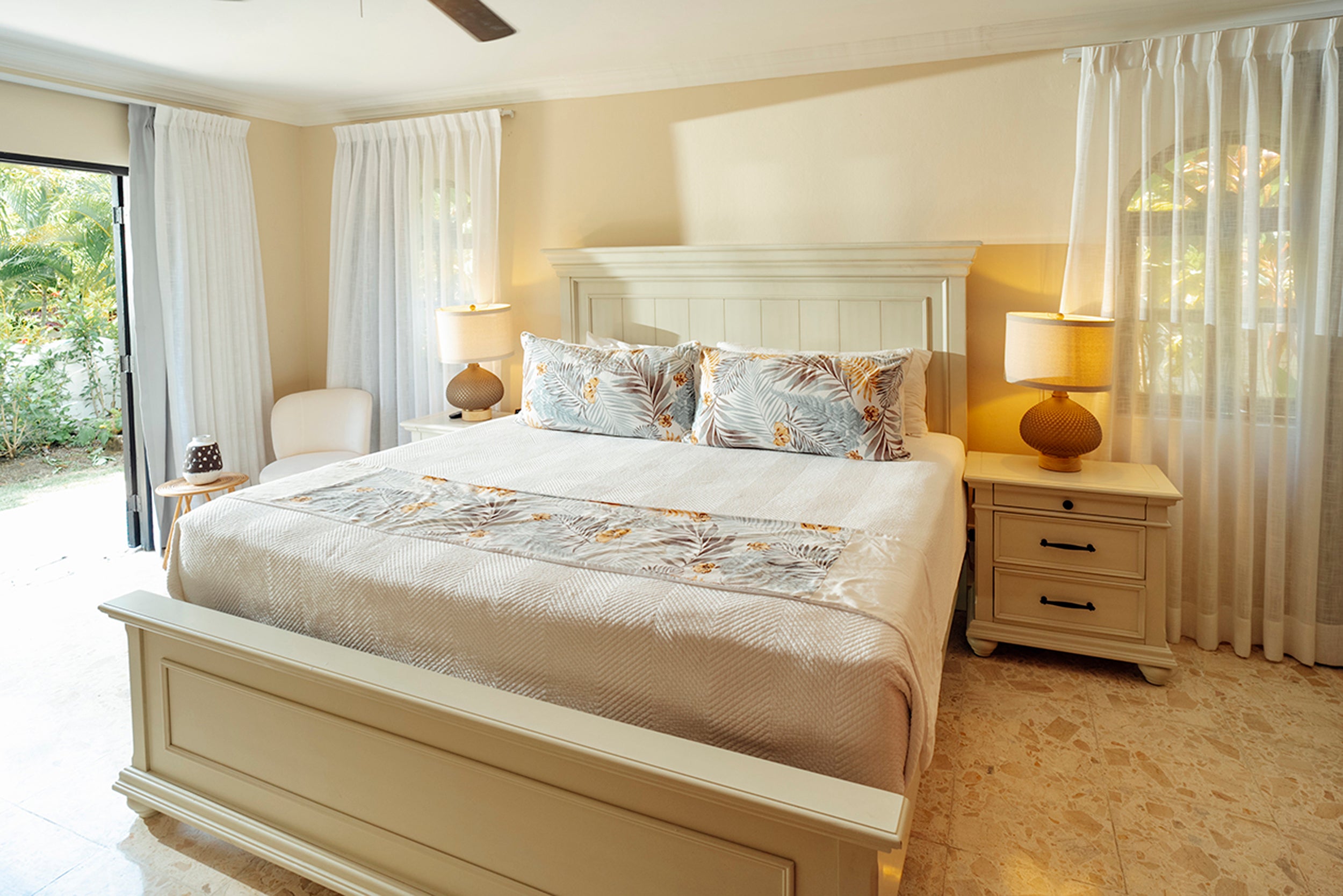 Neatly made bed in a bedroom with matching nightstands and lamps.