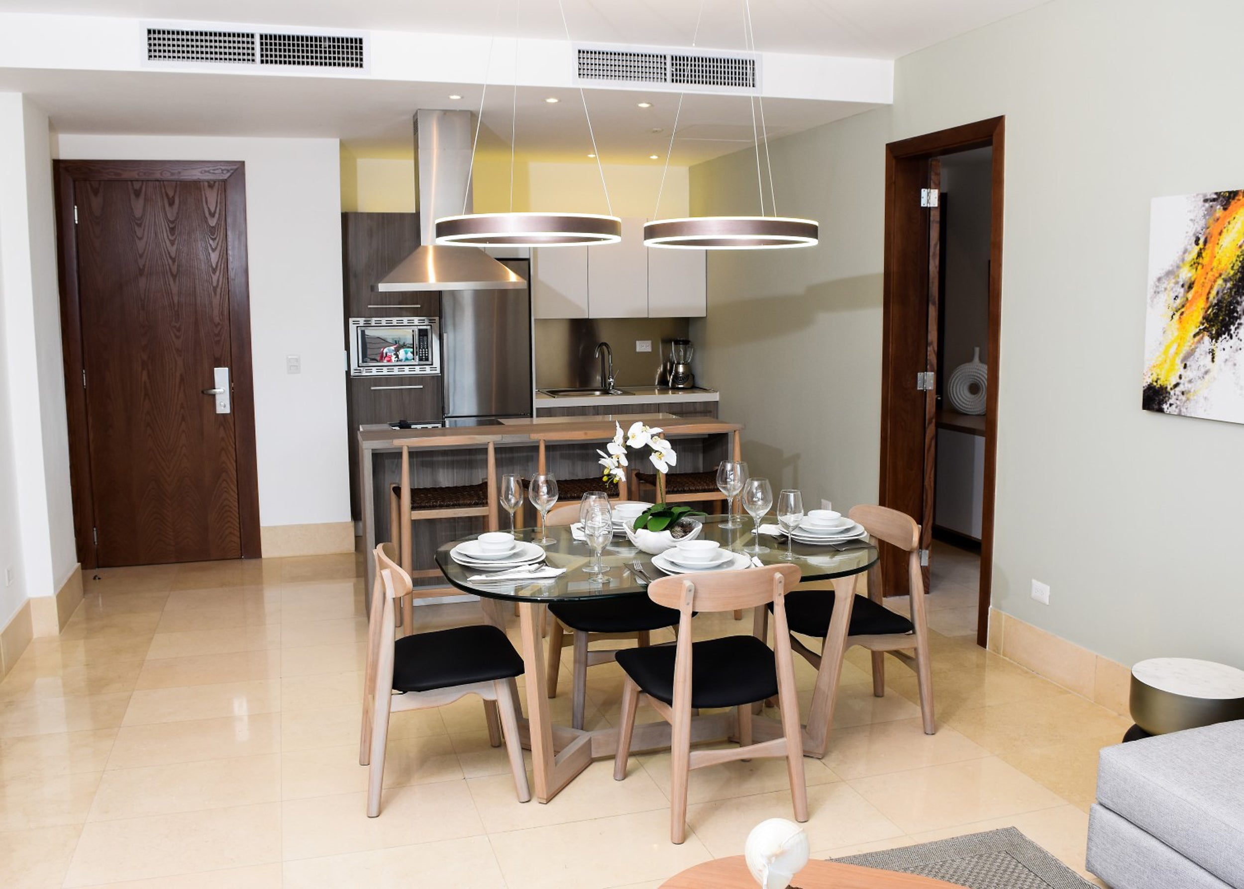 Modern kitchen and dining area with a glass dining table and chairs.