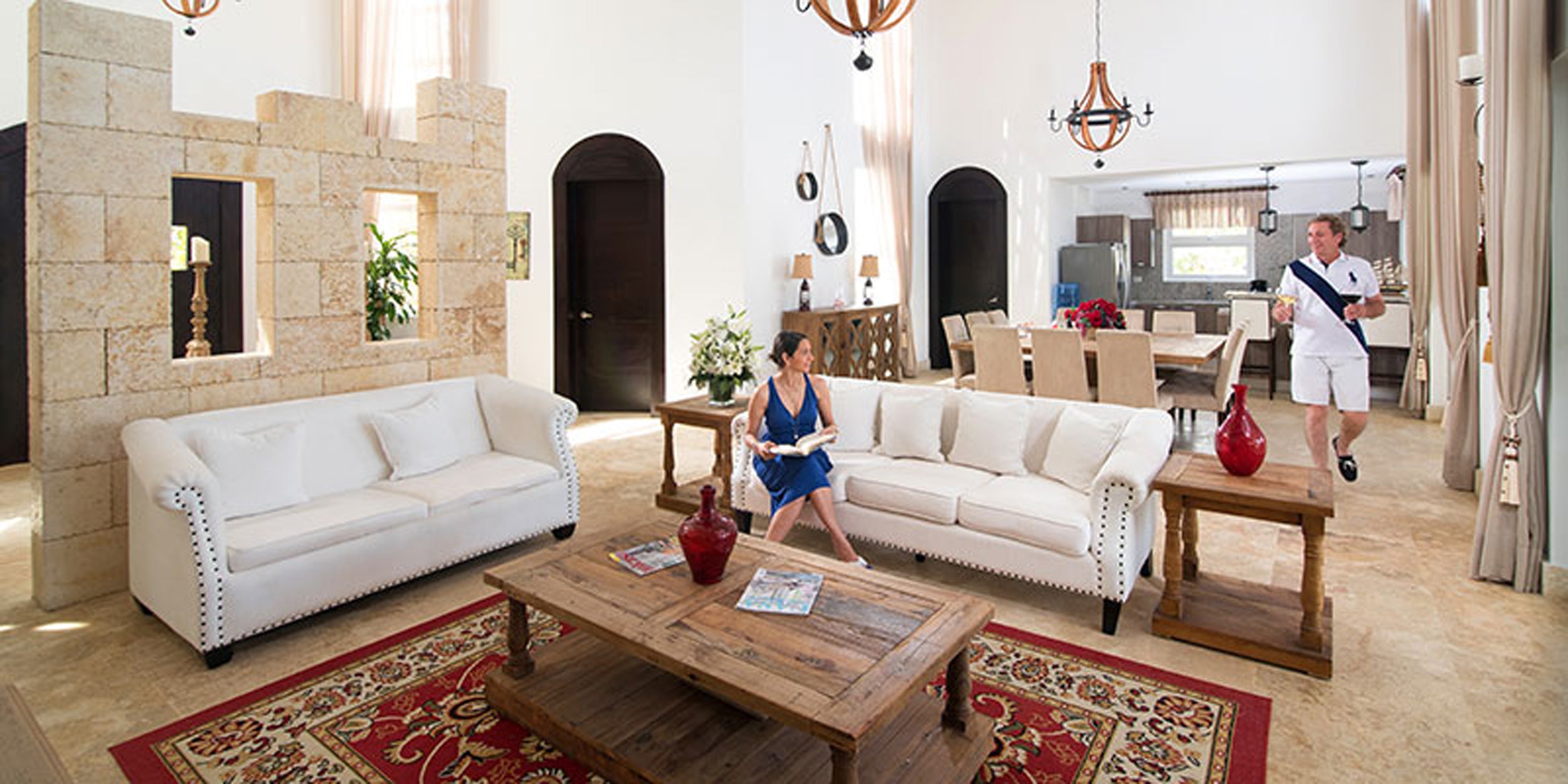 Living room with white sofas, wooden coffee table, and decorative items.