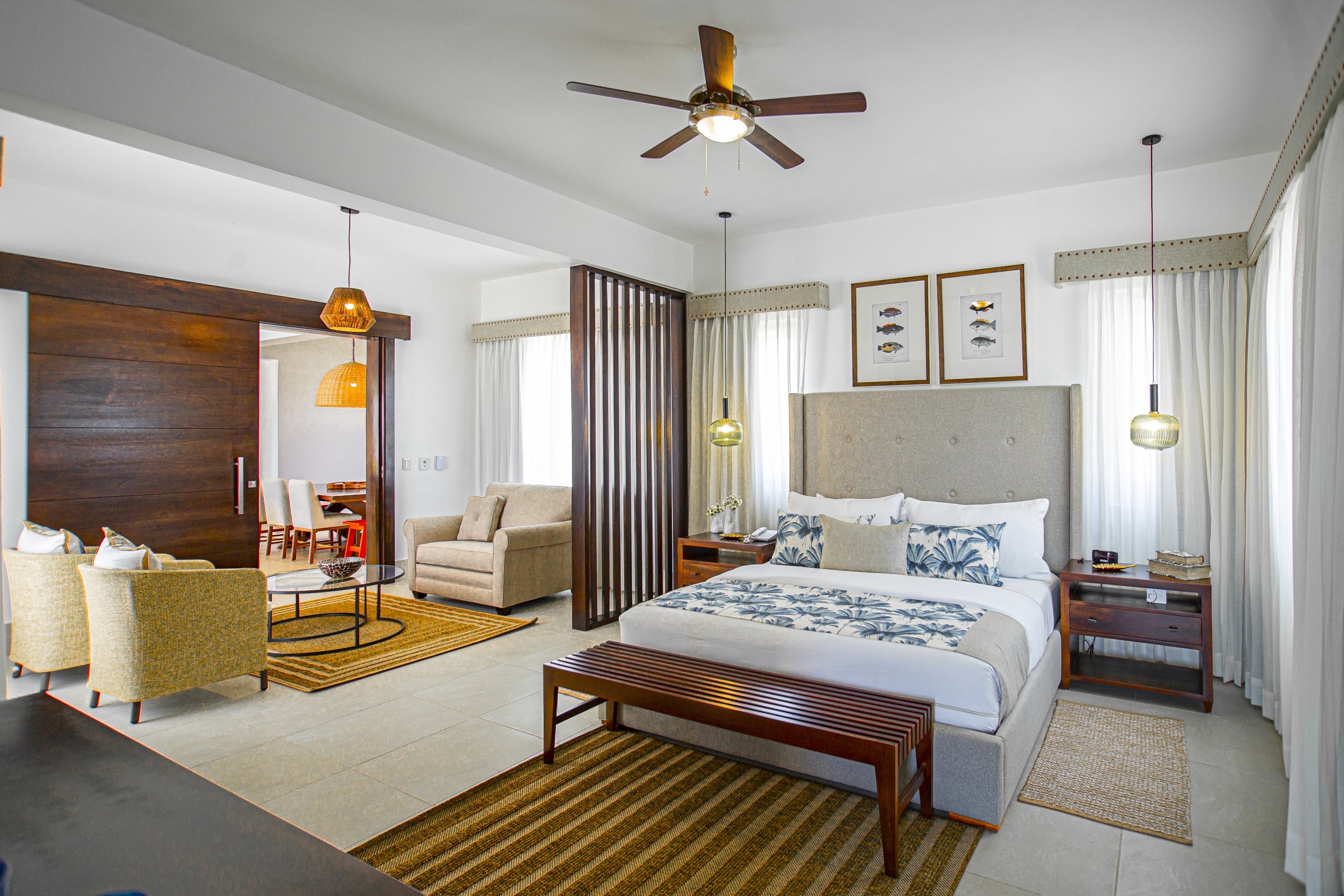 Modern master bedroom with a bed, sitting area, and decorative elements.