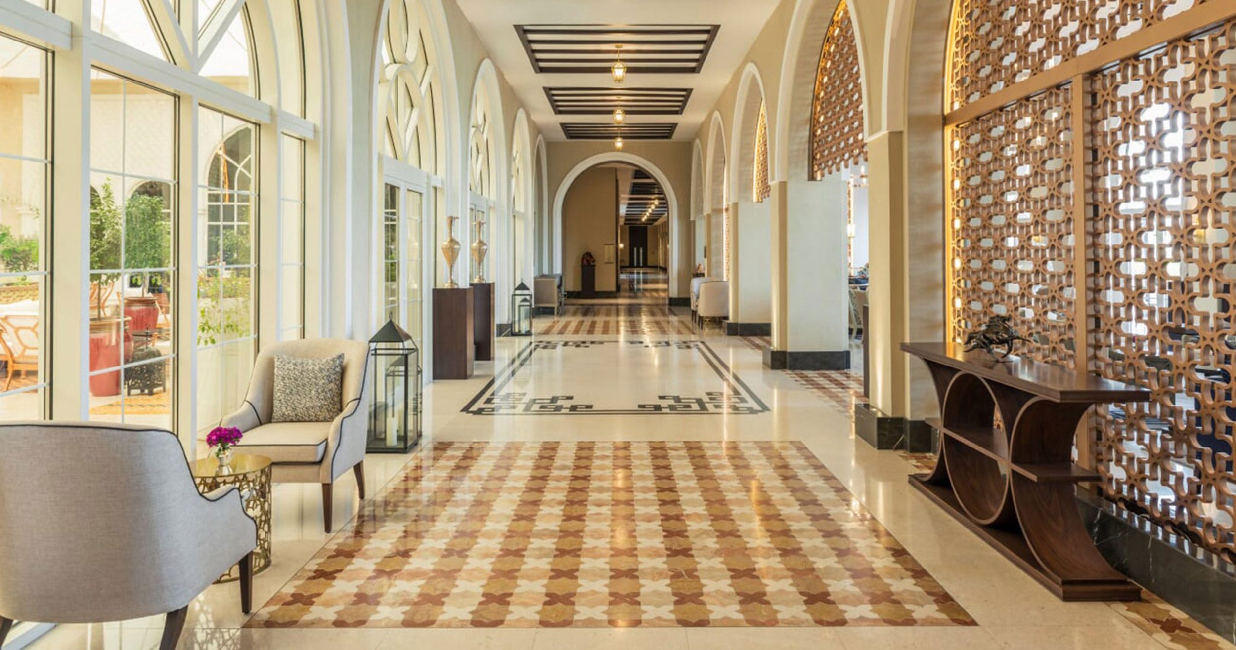 Luxurious hotel lobby with marble floors, elegant furniture, and decorative elements.