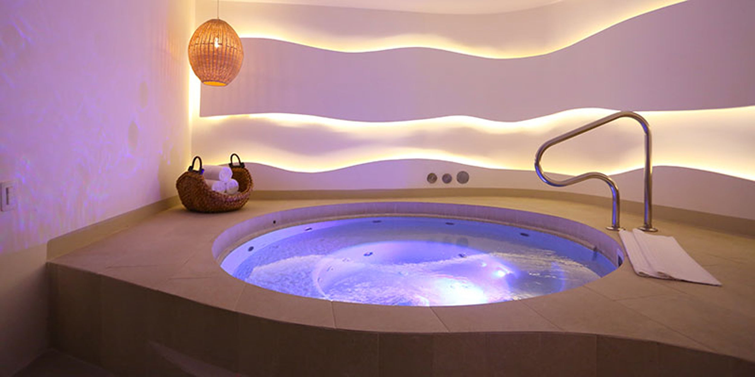 Modern corner hot tub with LED lighting in a spa-like setting