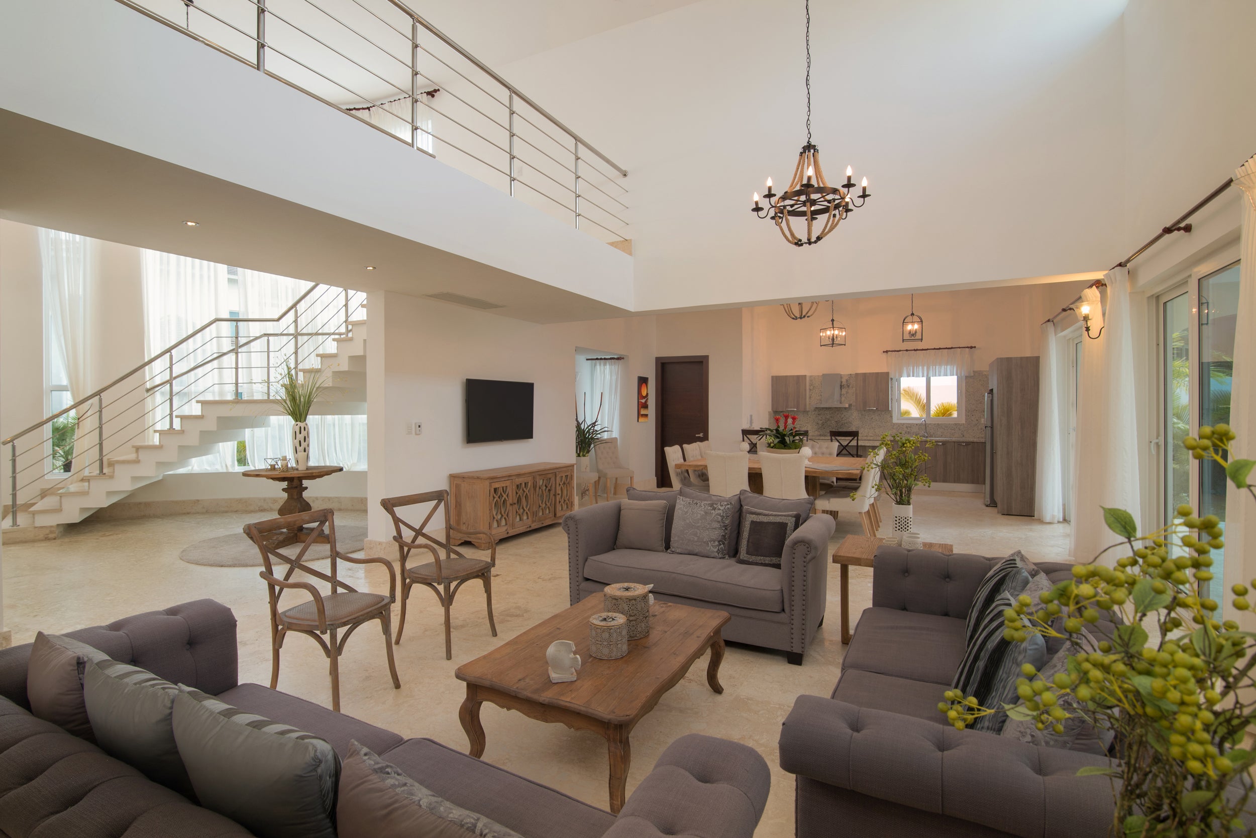 Modern living room with gray sofas, wooden coffee table, and kitchen in the background.