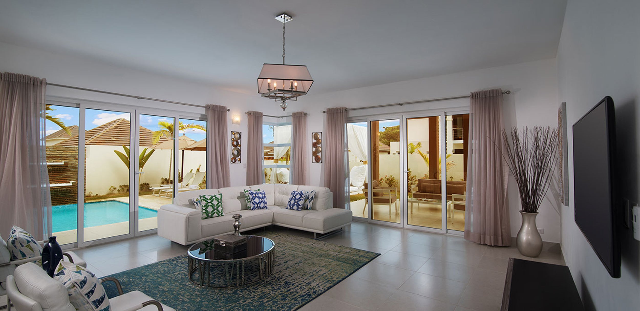 Modern living room with a pool view through large windows.